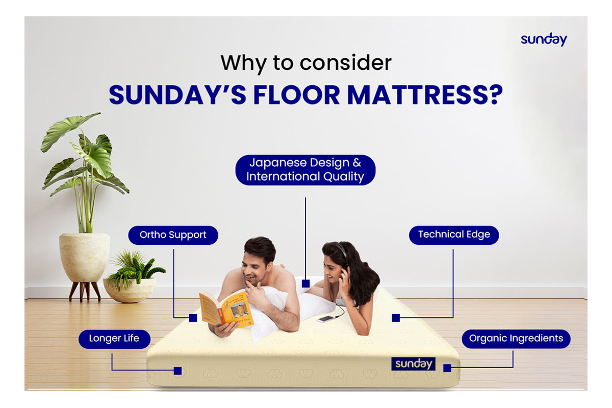A joyful couple sleeping on a Sunday floor mattress, reading a book in the man's hand